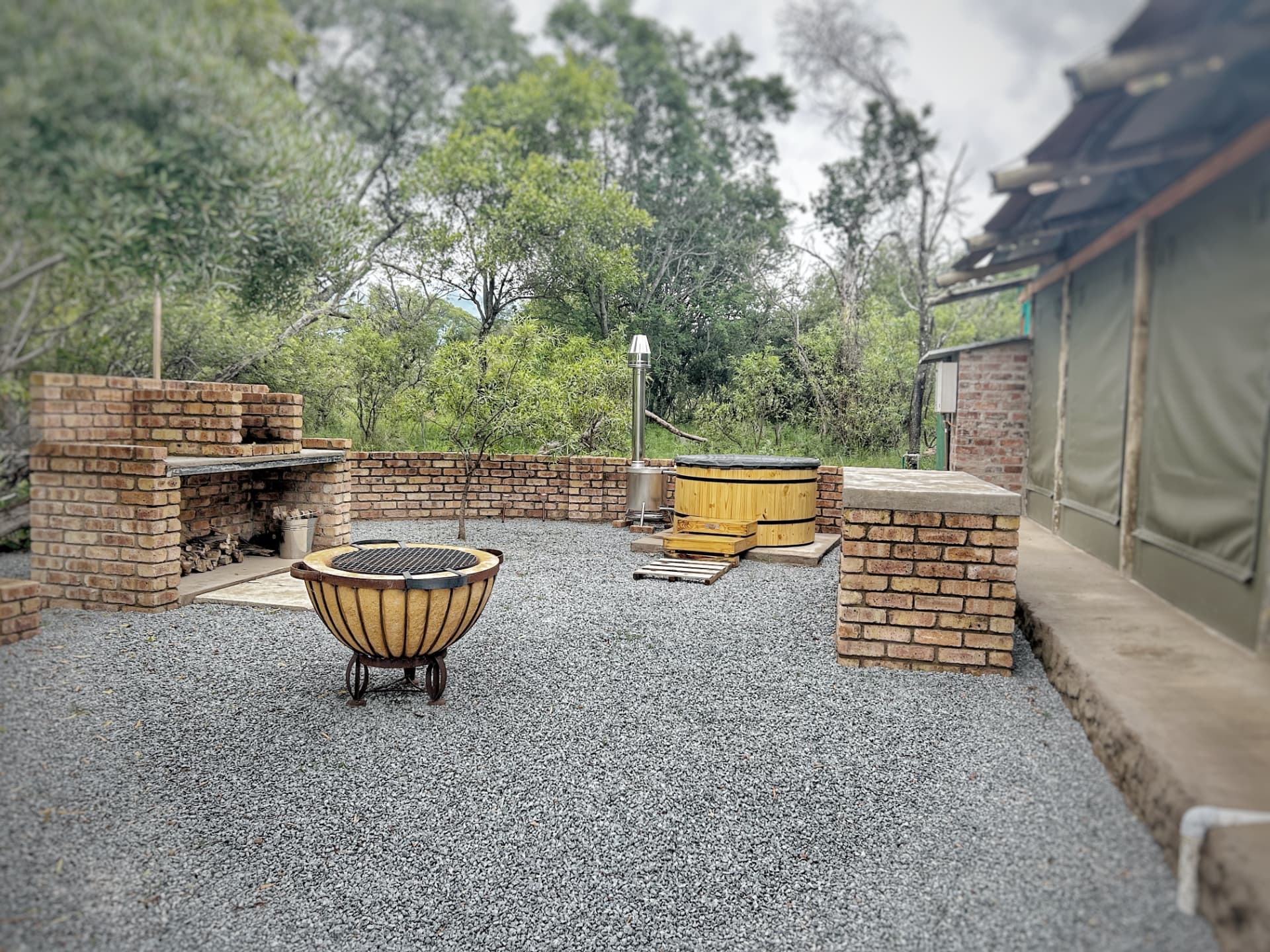 Outdoor boma with braai, fire pit and hot tub beside the tent