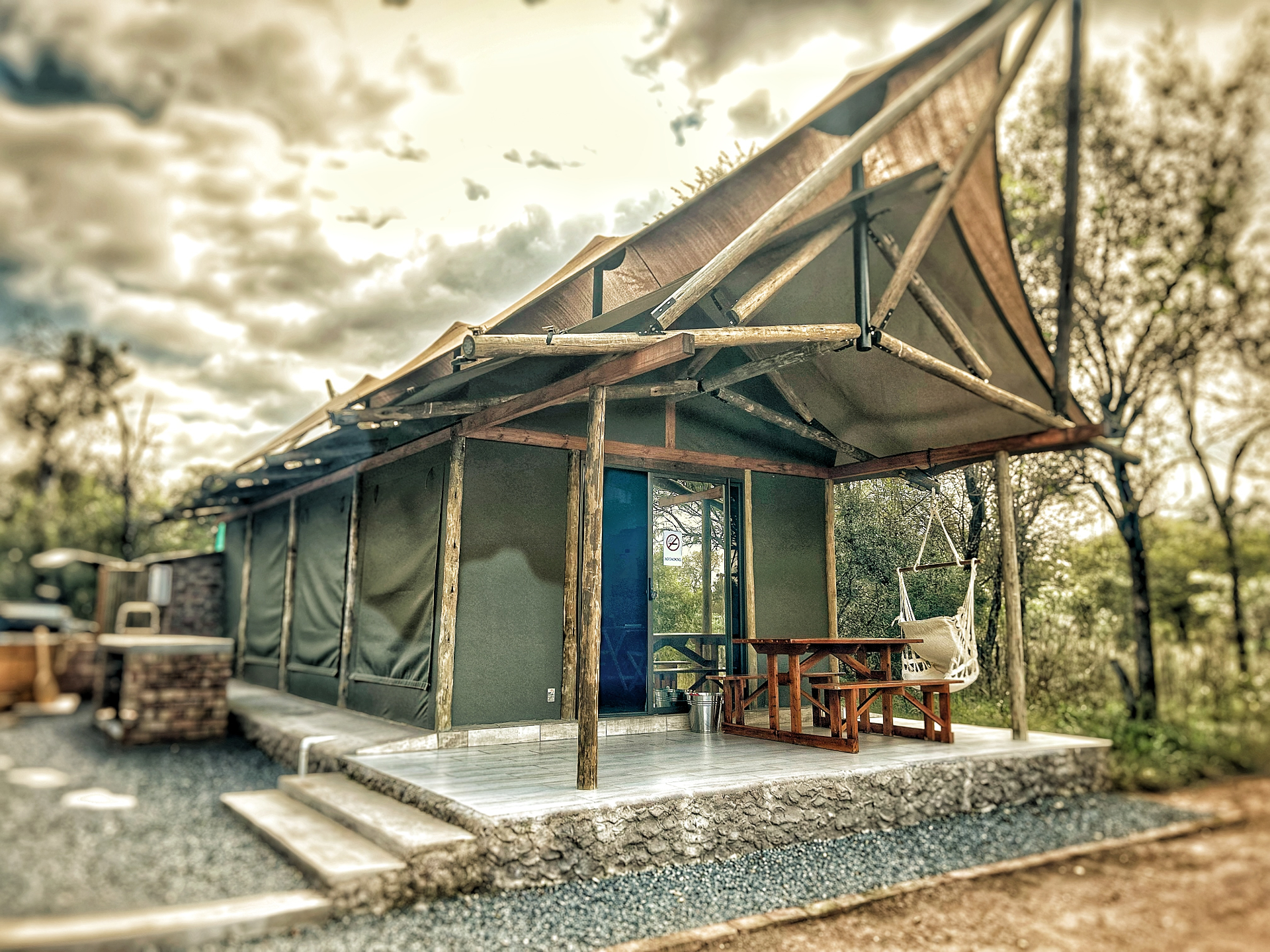 Wildeolyf Safari Tent at sunset overlooking a waterhole
